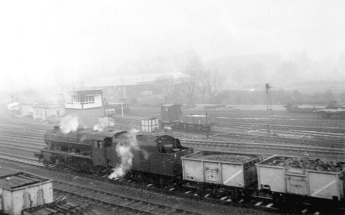 An unidentified ex-LMS 8F 2-8-0 locomotive is seen passing Water Orton Sidings Signal Box with a coal train bound for Washwood Heath Sidings
