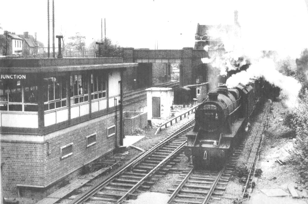 Ex-LMS 8F 2-8-0 No 48674 passes Water Orton East Junction Signal Box and takes the Kingsbury line with a Class F freight