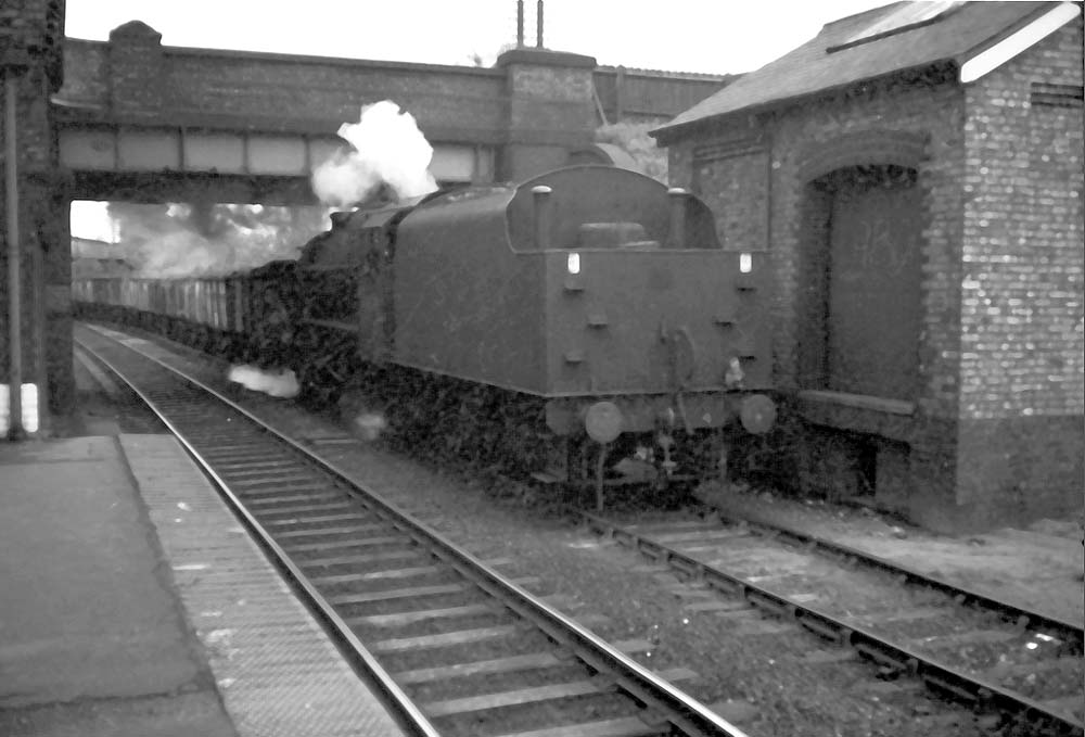 An unidentified ex-LMS 'Black 5' locomotive passes through Water Orton, running tender first, with a mineral train from the Nuneaton direction
