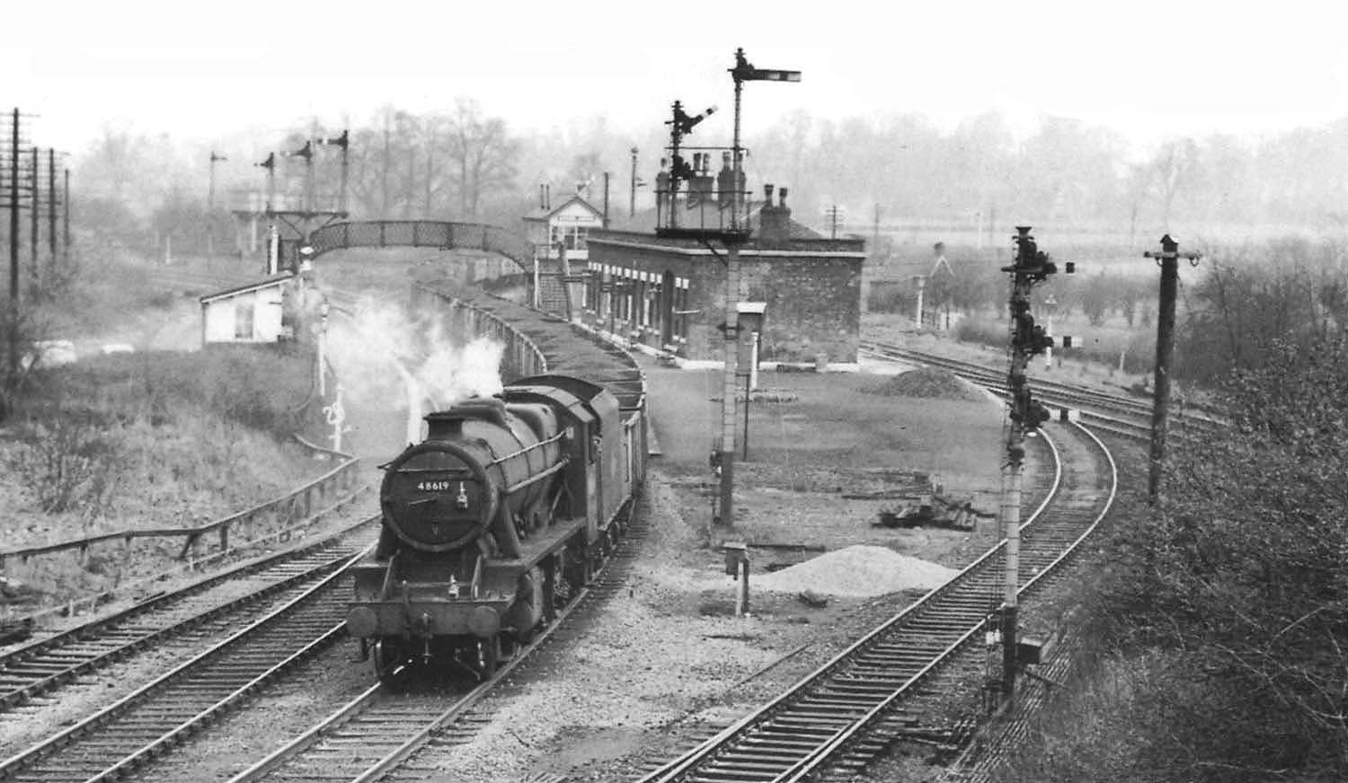 Ex-LMS 8F 2-8-0 No 48619 weaves its way through Whitacre Station on a coal train for Hams Hall
