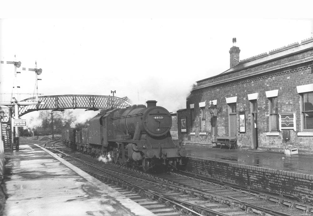 Ex-LMS 2-8-0 8F No 48135 trundles a mineral train through the station having just come off the line from Nuneaton