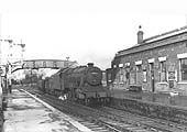 Ex-LMS 2-8-0 8F No 48135 trundles a mineral train through the station having just come off the line from Nuneaton
