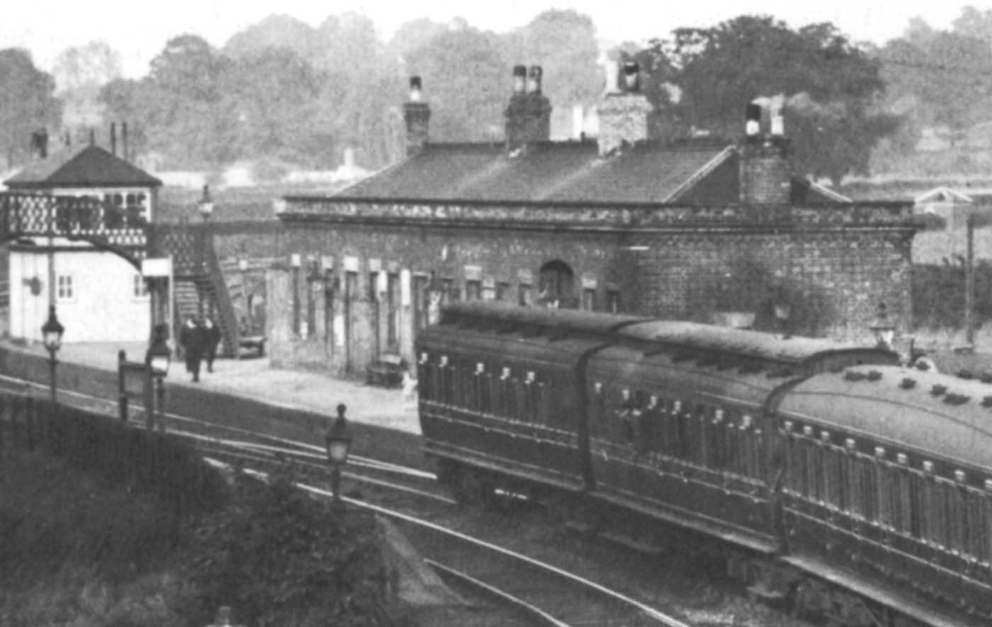 Close up showing the station building with signalbox located on the platform and footbridge to the opposite platform