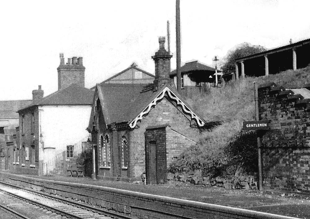 Close up showing Wilnecote station's down platform buildings and the booking office on the road above