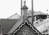 Close up showing the small timber structure with slate roof accommodating the station's booking office