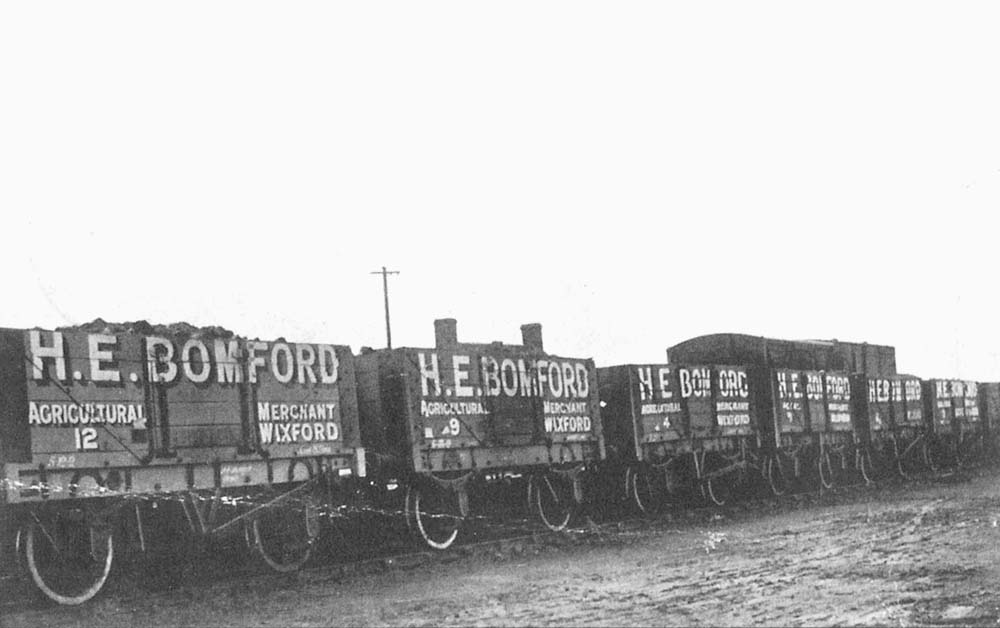 View of six five-plank open wagons employed by HE Bomford, an Agricultural Merchant based in Wixford, being used to carry coal