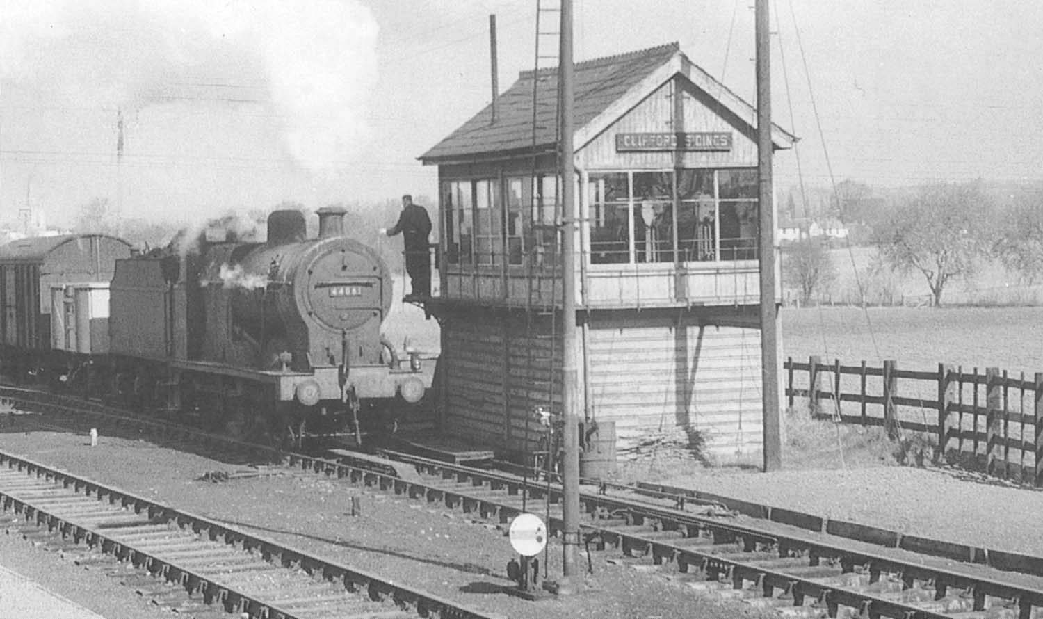 Close up showing the exchange of tokens between the 'bobby' of Clifford Sidings Signal Box and the engine crew
