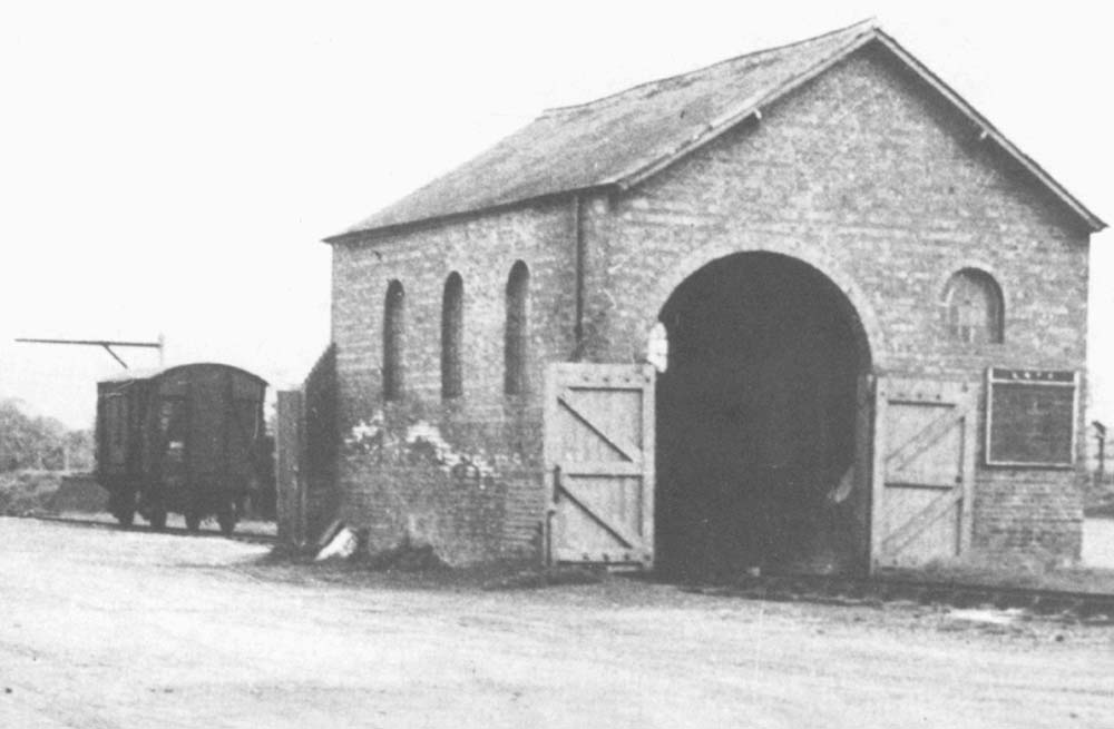 Close up showing Ettington station's brick built goods shed with its rear entrance doors open