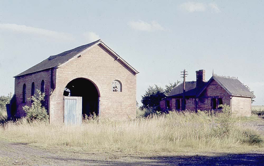 A colour view of the long abandoned goods shed and station building as seen on 17th July 1966