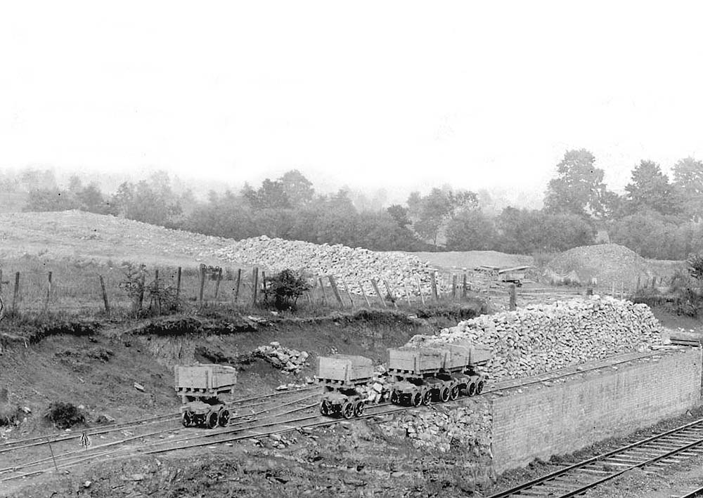 Close up showing four of the side-tipping wagons standing on the loading bank siding in Goldicote Cutting