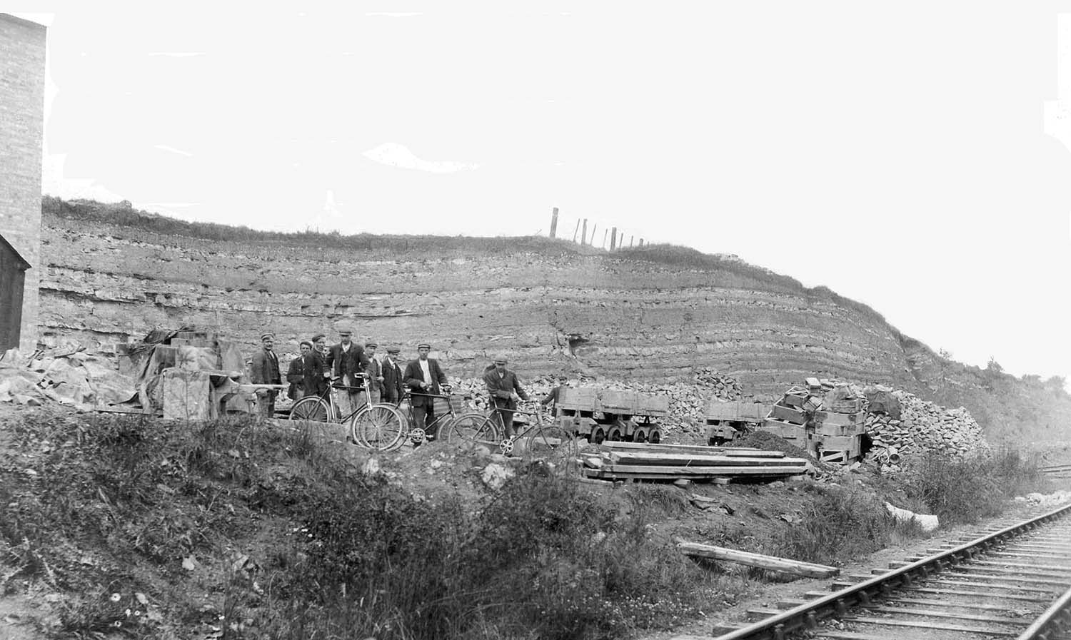 Men from the crushing plant pose with their bicycles with the E&WJR main line in the foreground