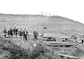 Close up of some of the narrow gauge side tipping wagons as some of the workmen prepare to go home
