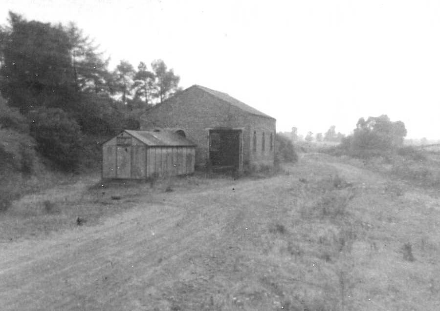 View of Kineton station's derelict goods shed and the former track bed of the SMJ on the right