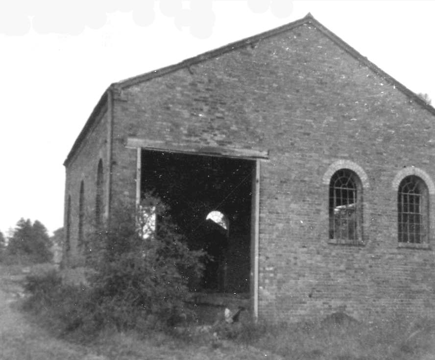 A close up view of Kineton station's goods shed showing the arched windows and the platform inside the shed