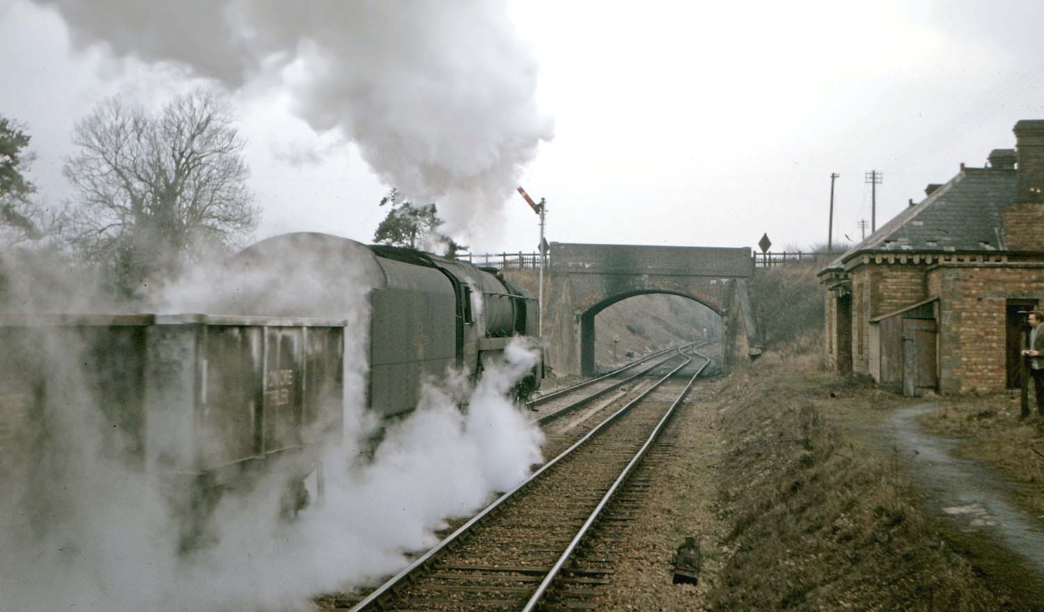 British Railways Standard Class 9F 2-10-0 No 92055 passes Kineton station with a train of iron ore wagons