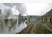 British Railways Standard Class 9F 2-10-0 No 92055 passes Kineton station with a train of iron ore wagons