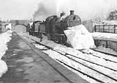 A pair of unidentified ex-LMS 4F 0-6-0 locomotives are seen clearing snow in Kineton station during the winter in early 1947