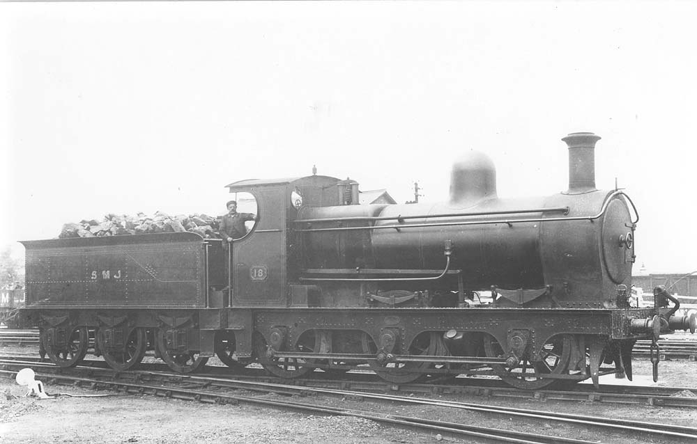 SMJ 0-6-0 No 18 stands outside Stratford on Avon shed with the driver posed for the camera