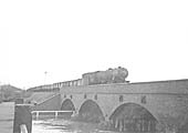 An unidentified ex-WD 2-8-0 locomotive is seen crossing the bridge carrying the former SMJ route over the River Avon