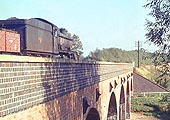 Ex-GWR 4-6-0 Hall class No 6940 'Didlington Hall' is seen crossing the River Avon on a freight to Fenny Compton