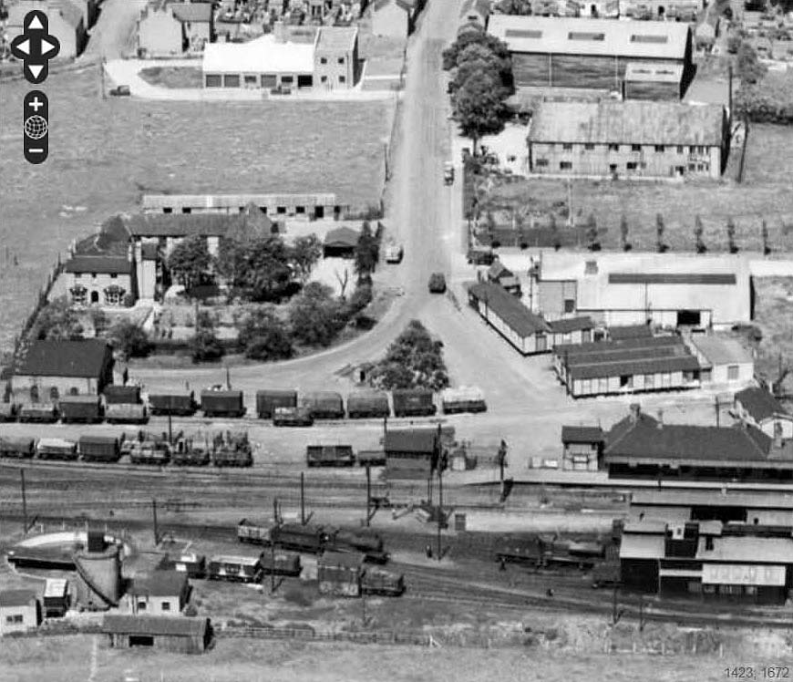 Close up showing the entrance to the station and a mix of wagons adjacent to the goods shed on 23rd June 1952