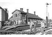 A visiting party of enthusiasts look around the near derelict E&WJR signal box and station building on 14th May 1960