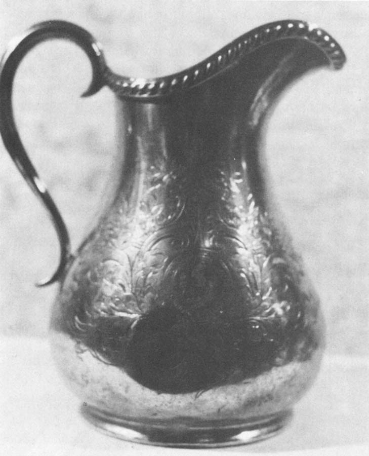 An ornamented silver milk jug, stamped 'London Midland & Scottish Railway Company' and emblazoned with its crest