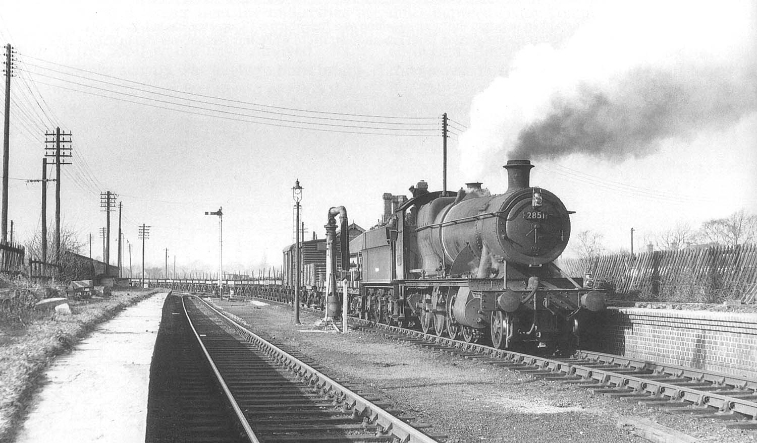 Ex-GWR 2-8-0 No 2851 pauses at the now derelict Stratford Old Town station in 1961 with a long train of 'flats'
