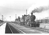 Ex-GWR 2-8-0 No 2851 pauses at the now derelict Stratford Old Town station in 1961 with a long train of 'flats'