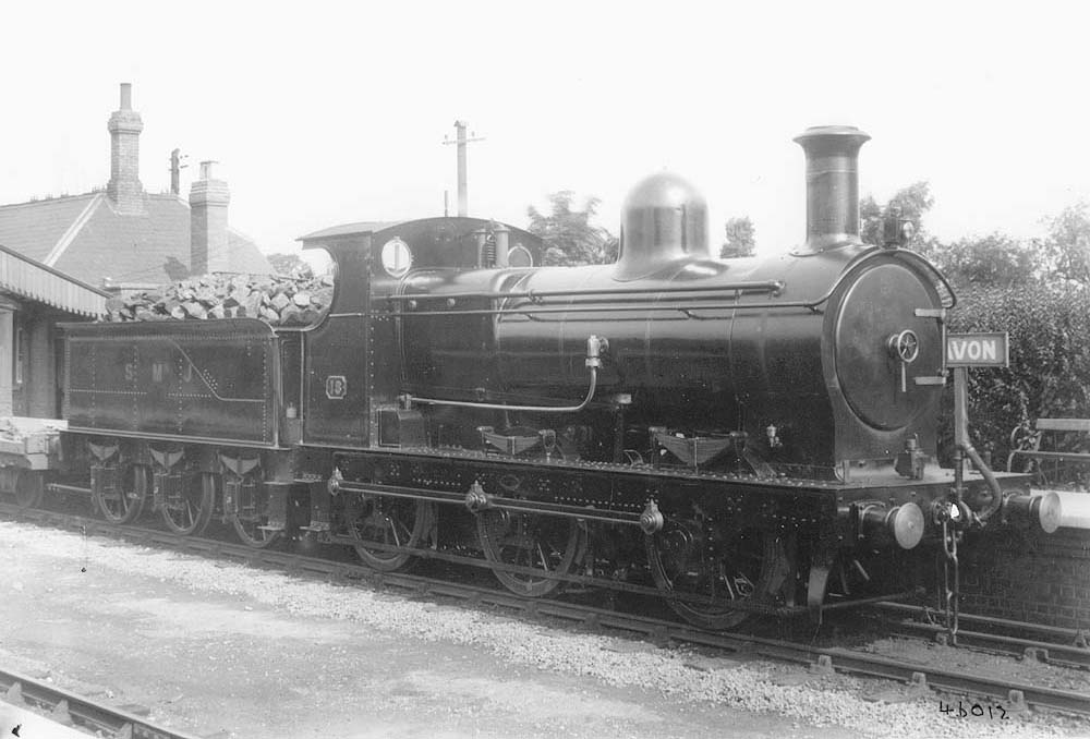 Ex-E&WJR 0-6-0 No 18 is seen on 11th April 1924 heading a goods train through the station past the up platform