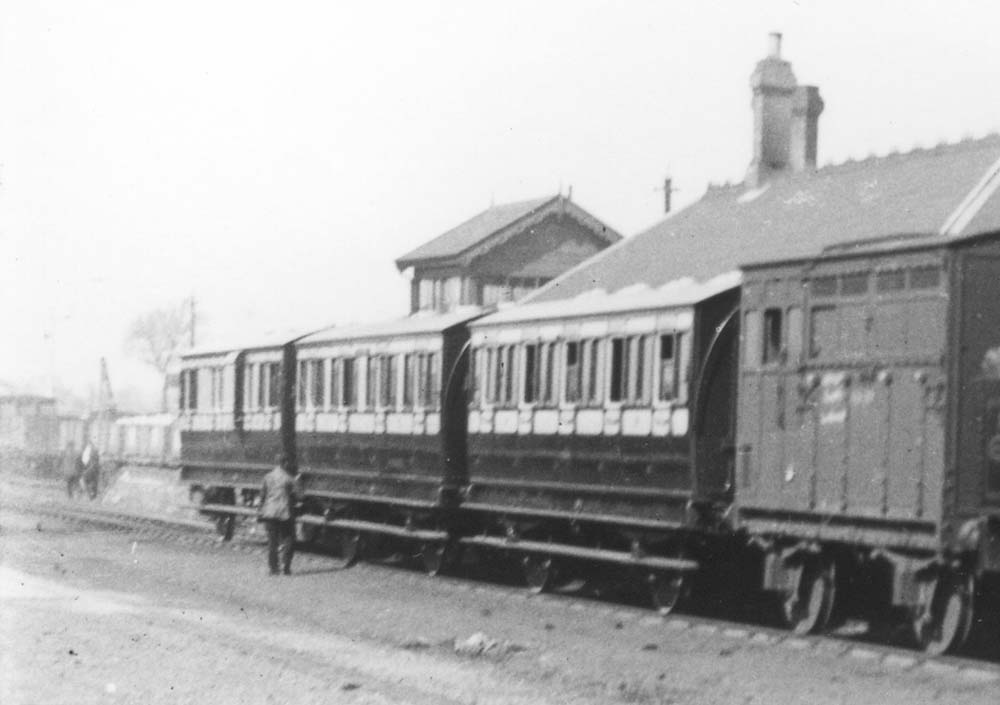 Close up showing the coaching stock wearing the pre-1909 livery of crimson lake below the waist and cream above