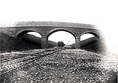 Contractor's temporary tracks snake their way beneath the three arch brick overbridge near Nethercote