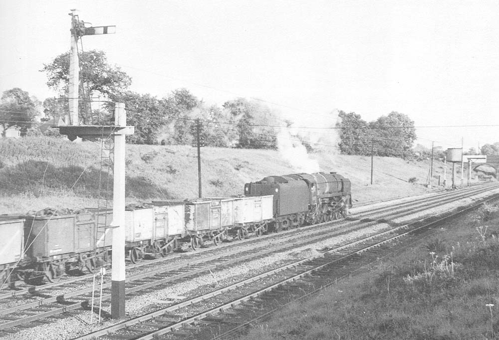 An unidentified British Railways Standard Class 9F locomotive is seen working hard on an up coal train during 1963