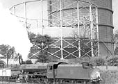 Ex-LMS 2-8-0 8F No 48258 is seen running tender first past Foleshill gasometers whilst at the head of a coal train