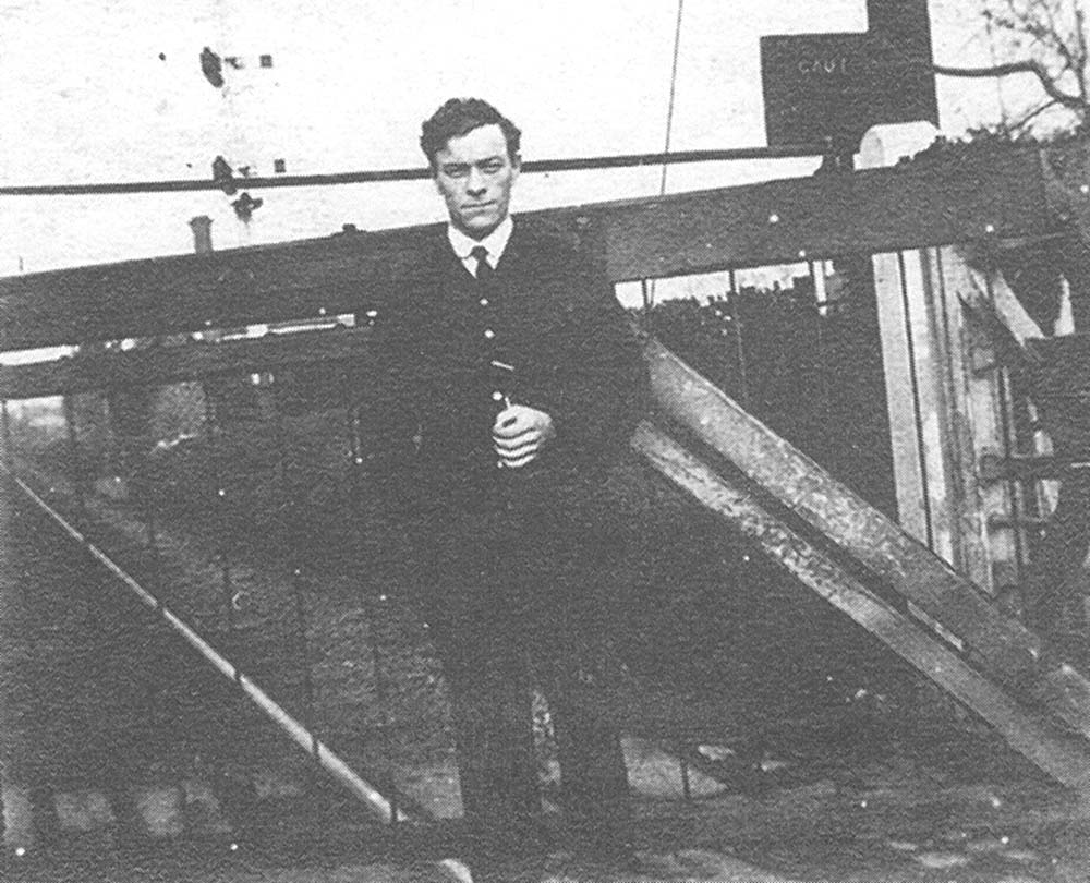 Bedlam Lane Crossing Signalman, Mr Gurney, poses for the camera in front of one of the level crossing gates