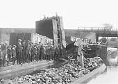 The fourth of a set of five photos of a rake of derailed loose coupled Newdigate Colliery wagons lying in Coventry Canal