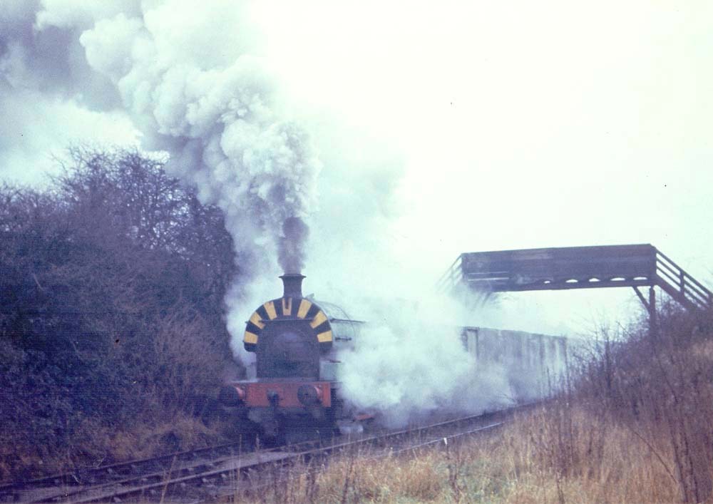 One of Newdigate Colliery's Peckett blasts away from the exchange sidings with a train of empties in the 1960s