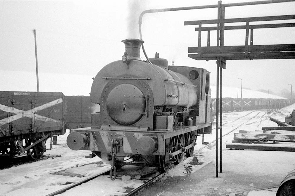 Newdigate Colliery's 0-6-0ST No 4 Peckett, built in 1933, is seen topping up its saddle tank adjacent to the colliery's shed