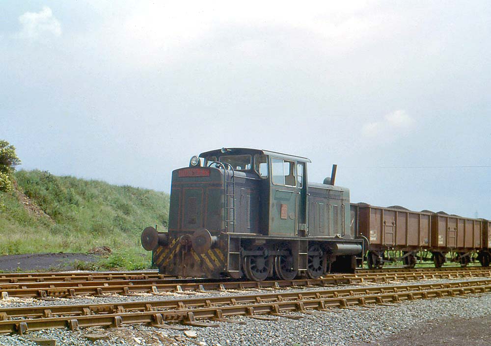 Hunslet Diesel Hydraulic 0-6-0 runs light engine past loaded steel bodied wagons on 26th June 1980